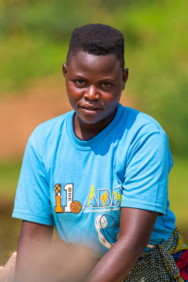 A young person in a bright blue T-shirt looking straight into the camera